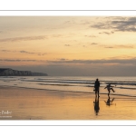 Promeneurs sur la plage d'Ault au soleil couchant