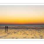 Couple sur la plage au soleil couchant