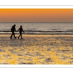 Couple sur la plage au soleil couchant