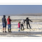 Enfants qui jouent sur la plage avec l'écume de mai