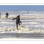 Enfants qui jouent sur la plage avec l'écume de mai