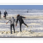 Enfants qui jouent sur la plage avec l'écume de mai