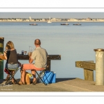 Des touristes pique-niquent devant la baie dans le port du Hourdel