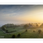 France, Somme (80), Baie de Somme, Saint-Valery-sur-Somme, la brume matianel se dissipe peu à peu et laisse appaitre le village et les hauteurs du cap hornu avec la chapelle des marins et le chenal de la Somme bordé des quais de promenade (vue aérienne) // France, Somme (80), Baie de Somme, Saint-Valery-sur-Somme, the morning mist gradually dissipates, revealing the village and the heights of Cap Hornu with the sailors' chapel and the Somme channel lined with pedestrian quays (aerial view)