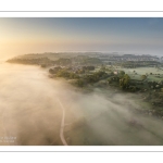 France, Somme (80), Baie de Somme, Saint-Valery-sur-Somme, la brume matianel se dissipe peu à peu et laisse appaitre le village et les hauteurs du cap hornu avec la chapelle des marins et le chenal de la Somme bordé des quais de promenade (vue aérienne) // France, Somme (80), Baie de Somme, Saint-Valery-sur-Somme, the morning mist gradually dissipates, revealing the village and the heights of Cap Hornu with the sailors' chapel and the Somme channel lined with pedestrian quays (aerial view)