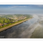 France, Somme (80), Baie de Somme, Saint-Valery-sur-Somme, la brume matianel se dissipe peu à peu et laisse appaitre le village et les hauteurs du cap hornu avec la chapelle des marins et le chenal de la Somme bordé des quais de promenade (vue aérienne) // France, Somme (80), Baie de Somme, Saint-Valery-sur-Somme, the morning mist gradually dissipates, revealing the village and the heights of Cap Hornu with the sailors' chapel and the Somme channel lined with pedestrian quays (aerial view)