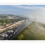 France, Somme (80), Baie de Somme, Saint-Valery-sur-Somme, la brume matianel se dissipe peu à peu et laisse appaitre le village et les hauteurs du cap hornu avec la chapelle des marins et le chenal de la Somme bordé des quais de promenade (vue aérienne) // France, Somme (80), Baie de Somme, Saint-Valery-sur-Somme, the morning mist gradually dissipates, revealing the village and the heights of Cap Hornu with the sailors' chapel and the Somme channel lined with pedestrian quays (aerial view)