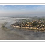 France, Somme (80), Baie de Somme, Saint-Valery-sur-Somme, la brume matianel se dissipe peu à peu et laisse appaitre le village et les hauteurs du cap hornu avec la chapelle des marins et le chenal de la Somme bordé des quais de promenade (vue aérienne) // France, Somme (80), Baie de Somme, Saint-Valery-sur-Somme, the morning mist gradually dissipates, revealing the village and the heights of Cap Hornu with the sailors' chapel and the Somme channel lined with pedestrian quays (aerial view)