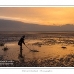 Enfant jouant dans les flaques avec un baton. Saison : hiver - Lieu : Le Crotoy, Baie de Somme, Somme, Picardie, France.