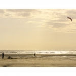 Famille jouant au cerf-volant sur la plage