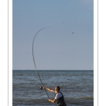 Pêcheur à la ligne sur la plage entre les bouchots