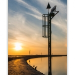 Promenade le long du chenal de la Somme Ã  Saint-Valery, au Cap Hornu alors ques les nuages colorÃ©s par le soleil couchant se reflÃ¨tent dans l'eau. Saison : Ã©tÃ© - Lieu : Cap Hornu, Saint-Valery-sur-Somme, Baie de Somme, Somme, Picardie, France.
