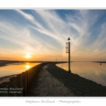 Promenade le long du chenal de la Somme Ã  Saint-Valery, au Cap Hornu alors ques les nuages colorÃ©s par le soleil couchant se reflÃ¨tent dans l'eau. Saison : Ã©tÃ© - Lieu : Cap Hornu, Saint-Valery-sur-Somme, Baie de Somme, Somme, Picardie, France.